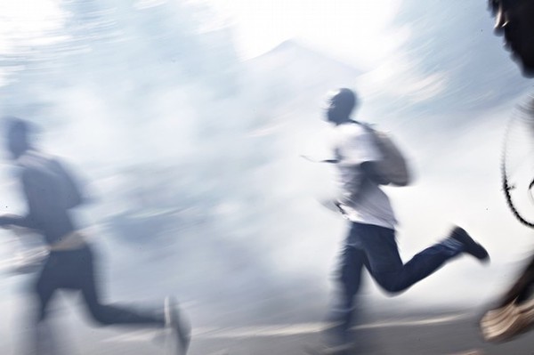 Protestors Run Through A Cloud Of Tear Gas During A Demonstration In Dakar